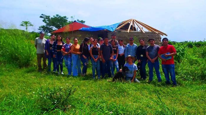 Grupo de estudiantes frente a una construcción de bahareque en Pakkitlán